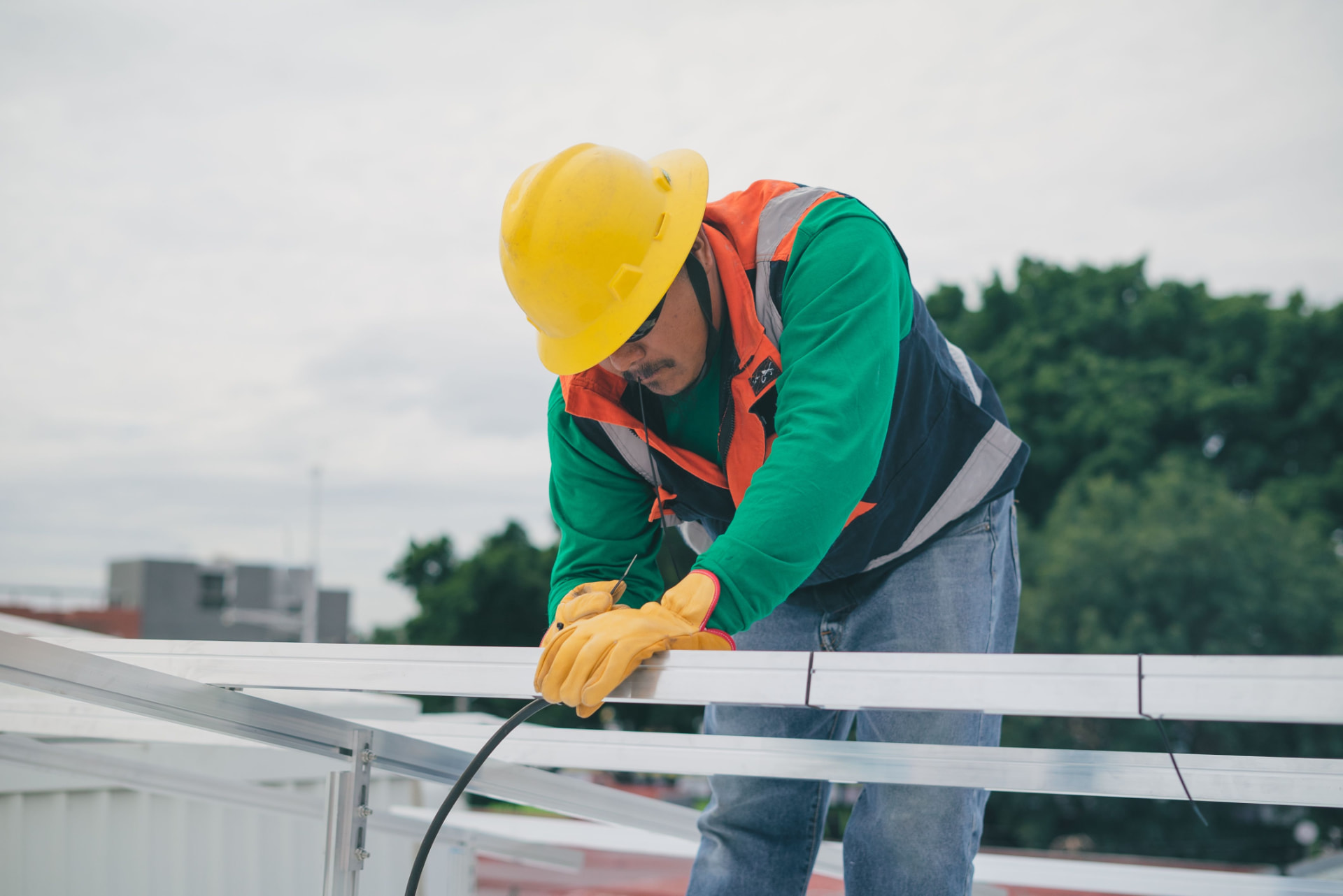 Profesional de instalaciones eléctricas con casco trabajando en una estructura exterior